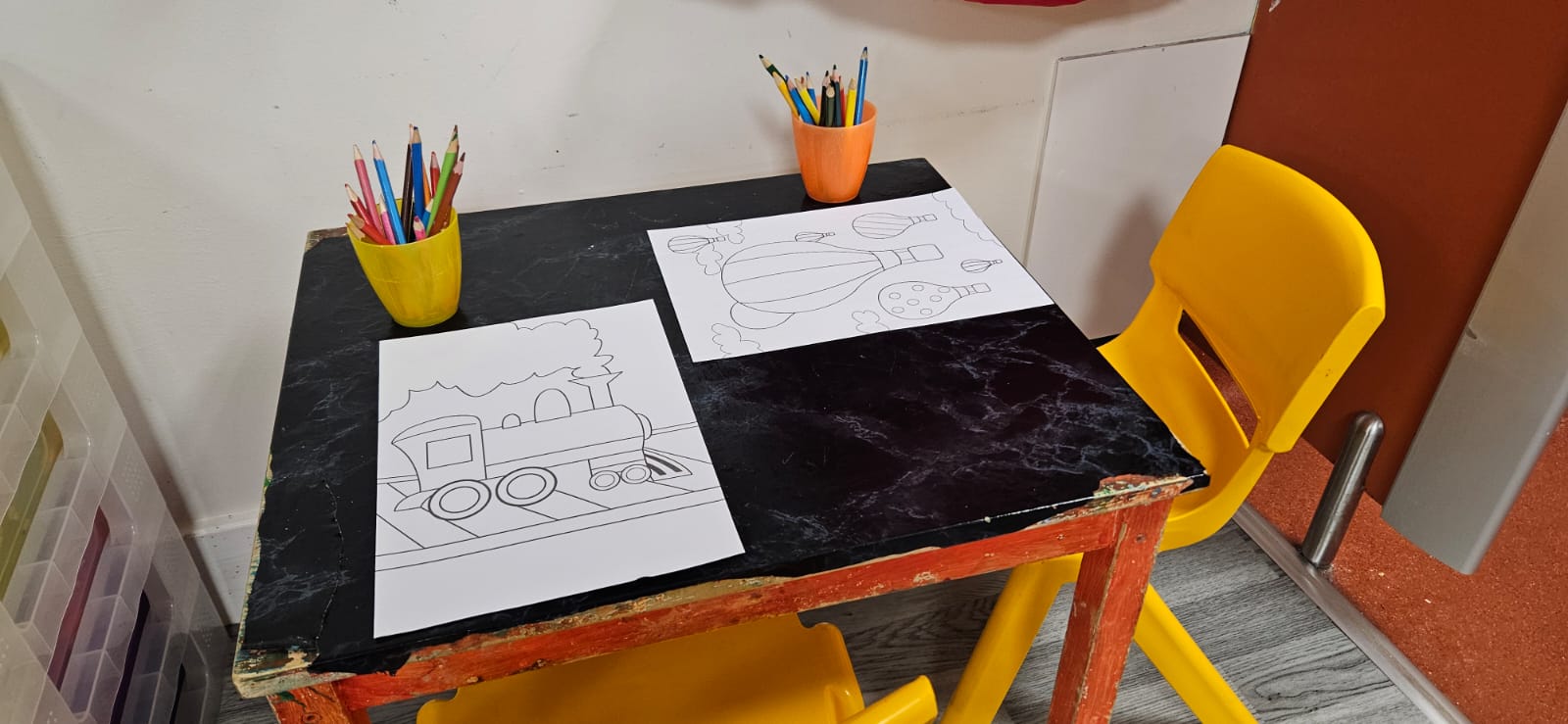 Small drawing table with colouring pages and pots of pencils