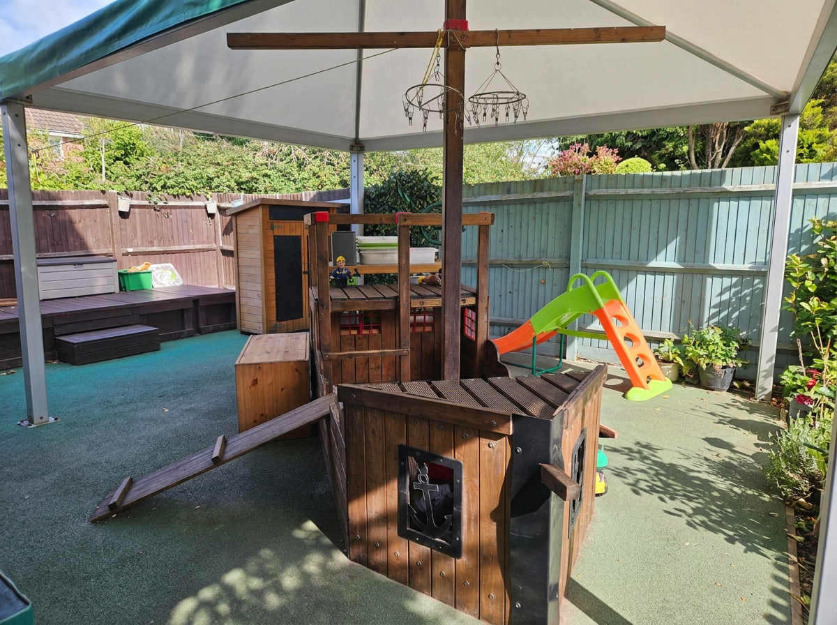 Pirate ship, slide and covered play space in the nursery garden