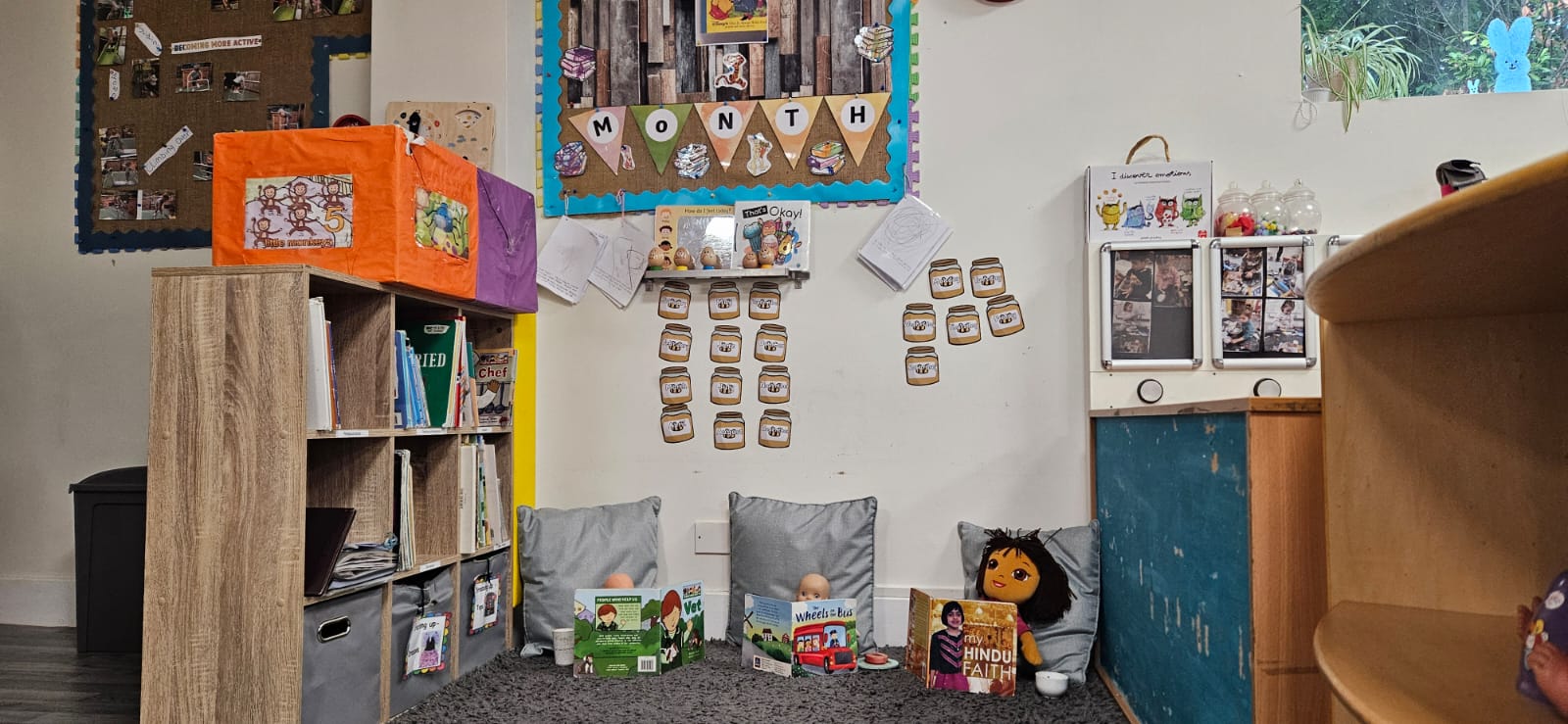 Cosy book corner with cushions, picture books and wall displays