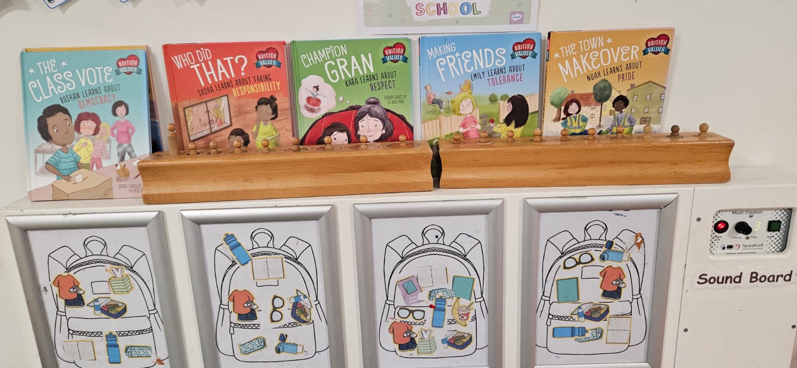 Shelf of British Values story books above children's coat pegs